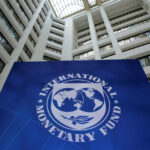 Nigeria growth forecast IMF headquarters building interior with large IMF logo sign displayed in a modern atrium