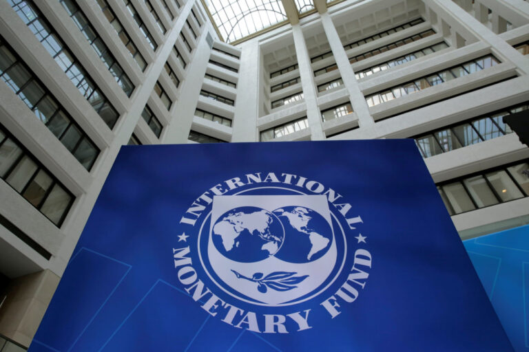 Nigeria growth forecast IMF headquarters building interior with large IMF logo sign displayed in a modern atrium